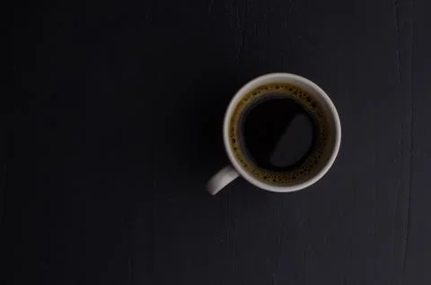 Black closeup on dark backdrop. Coffee espresso on dark background. Stock Photos
