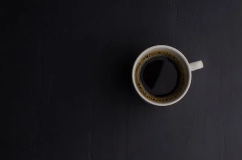 Black closeup on dark backdrop. Coffee espresso on dark background. Stock Photos