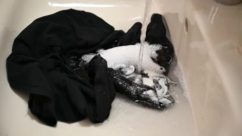 Black clothes are swaying inside the bathroom sink Stock Footage 257273964