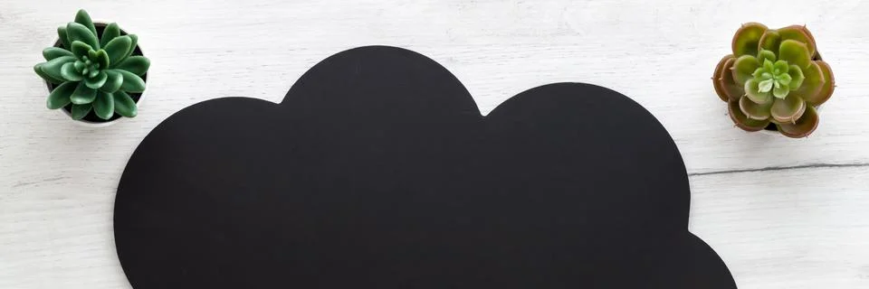 Black cloud with space for text on white wooden table. Copy space. Top view. Stock Photos