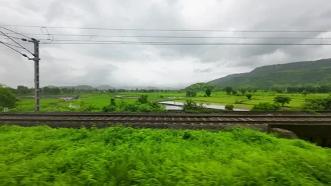 Black clouds and greenery forest hyper lapse view from train window in Stock Footage 248489475