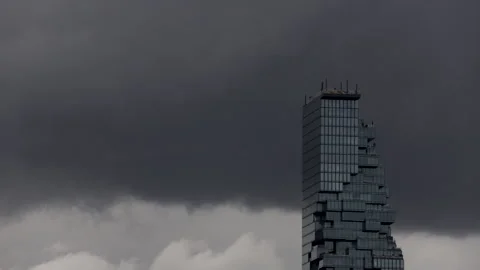 Black clouds are moving past Sathorn Tower, the tallest building in Bangkok Stock Footage 314244253
