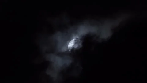 Black clouds float smoothly across the full moon at night. Dramatic Halloween Stock Footage 233503772