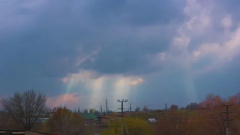 Black clouds with rays of the sun, slowly floating across the blue sky. Stock Footage 224261511