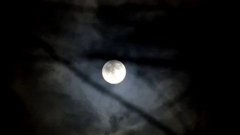 Black clouds run through the night sky against the background of the cold moon Stock Footage 84086683