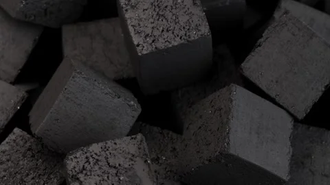 Black coal cubes spin in circle on dark background showing detailed rough Stock Footage 311326633