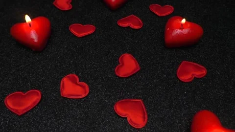 On a black coating, burning hearts in the form of candles and fabric hearts Stock Footage 169761889