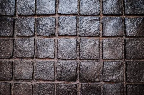 Black cobbled stone road with reflection of light texture background Stock Photos
