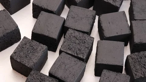 Black coconut charcoal cubes for hookah rotating in circle on white background Stock Footage 311325858