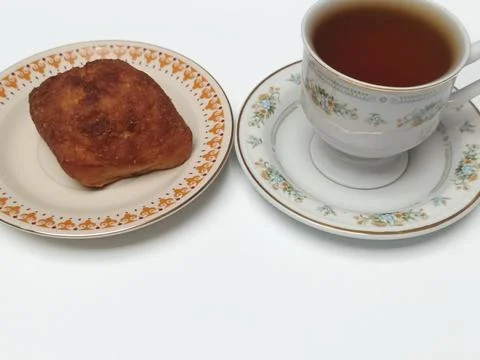 Black Coffee and Fried Bread on Vintage Saucer Plate 库存照片
