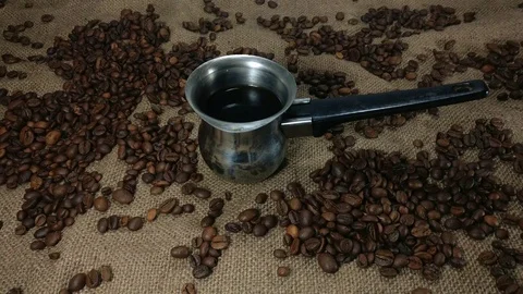 Black coffee and roasted beans on background of bagging Stock Footage 75526094