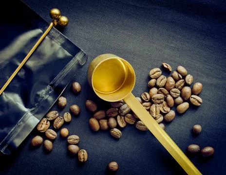 Black coffee bag with closed clamp, measuring spoon and coffee beans, stylize Stock Photos