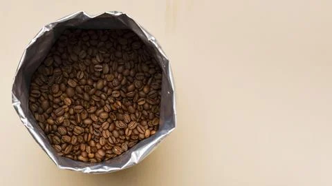 Black coffee beans beige background with copy space Stock Photos
