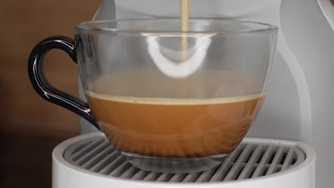 Black coffee being poured in transparent cup with capsule coffee mashine Stock Footage 88988390