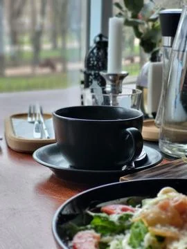 Black Coffee Cup on Cafe Table Close Up Stock Photos