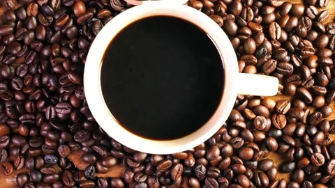 Black coffee in the cup, Dark Coffee beans on the old wooden floor Video stock 197461534