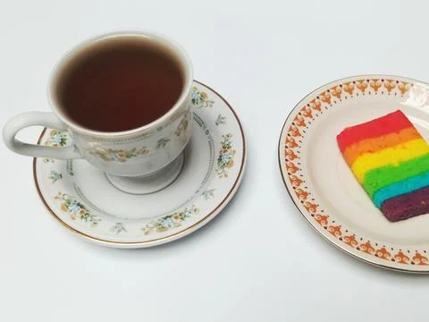 Black Coffee Cup with Rainbow Layer Cake Slice 库存照片