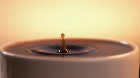 Black coffee drop into the filled Cup from the coffee machine in slow motion Stock Footage 140249708