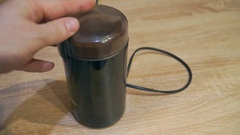 Black coffee grinder is on the table and works 스톡 동영상 120287470