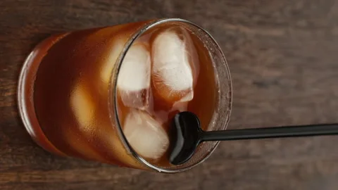 Black coffee with ice. Making iced coffee. Vertical video Stock Footage 243080474