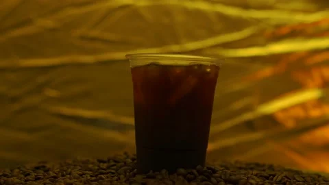 Black Coffee Iced In Disposable Plastic Cup On Roasted Coffee Bean Rotated. Stockbeeldmateriaal 196776423