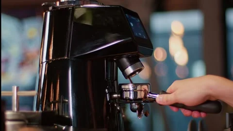 Black coffee machine grinds and brews coffee, the hand of barista brings a Видео 262202941