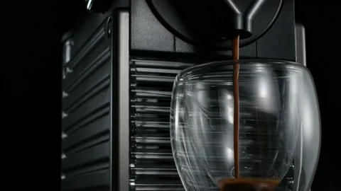 Black coffee machine pouring hot drink into the glass cup Stock Footage 133035559