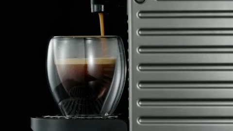 Black coffee machine pouring hot drink into the glass cup Stock Footage 133037592