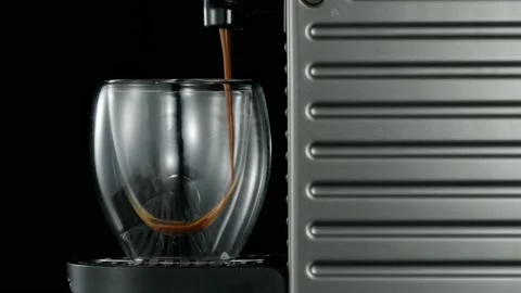 Black coffee machine pouring hot drink into the glass cup Stock Footage 133048078