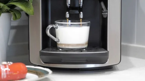 A black coffee machine pours coffee into a transparent cup, close-up Stock Footage 126318091