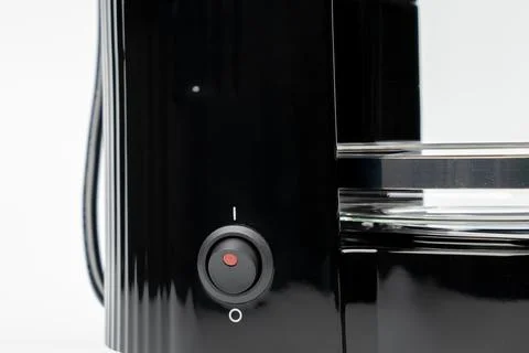 A black coffee maker with a red button on the side Stock Photos