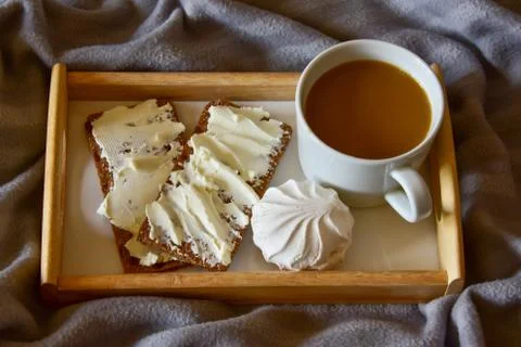 Black coffee with marshmallows, bread rolls with butter, on a wooden tray. mo Foto stock