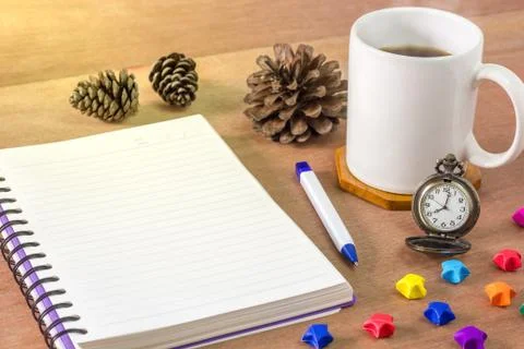 Black coffee with a notebook on a brown table. Stock Photos