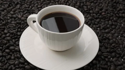 Black coffee in white cup isolated on background of roasted coffee beans. Stock Footage 242829009