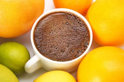 Black coffee in a white Cup surrounded by citrus fruits Stock Photos