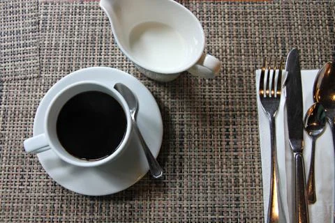 Black coffee in a white cup on the table and a glass of milk nearby. Foto stock