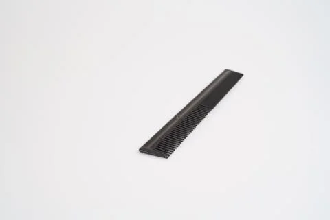 Black comb with selective focus on light table Stock Photos