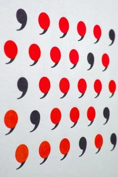 Black comma in many red commas. Stock Photos