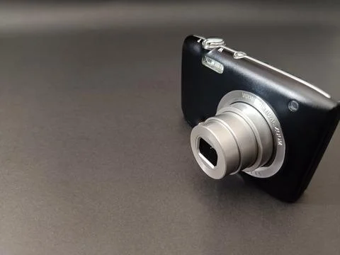 A black compact digital camera with an extended silver optical zoom lens. Stock Photos