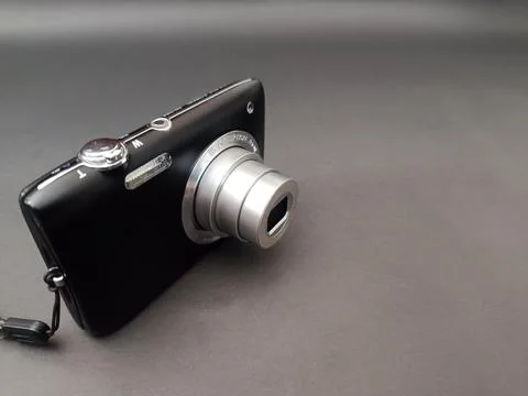 A black compact digital camera with an extended silver optical zoom lens. Stock Photos
