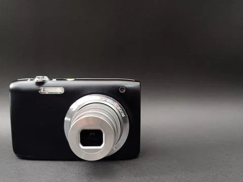 A black compact digital camera with an extended silver optical zoom lens. Stock Photos