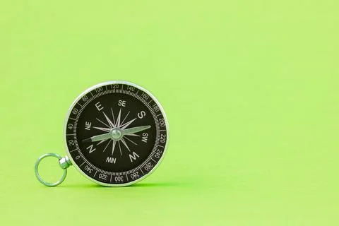 Black compass on the green background Stock Photos
