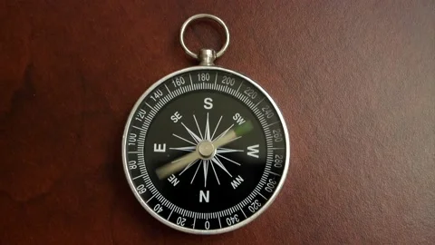Black compass on wooden table with rotating pointer. Stock Footage 154991239