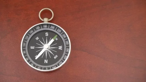 Black compass on wooden table with rotating pointer, room for text. Stock Footage 269889549