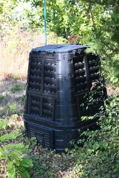 Black compost bin in a garden Stock Photos