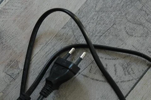 Black computer cable lying on a gray floor 写真素材