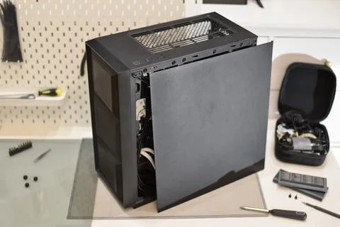 Black computer case with side panel removed, internal components, tools Foto stock
