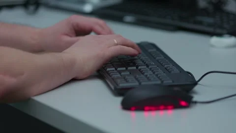 A black computer keyboard and a red computer mouse are on a table Stock Footage 277694954