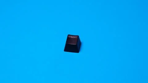 Black computer keyboard isolated on blue background. Copy space for text. Stock Photos