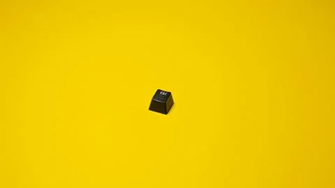 Black computer keyboard isolated on yellow background. Copy space for text. Stock Photos
